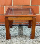 MOBILIÁRIO - Bela mesa de canto em mogno maciço, quadrada e com tampo de vidro, dotada de design clean e atemporal. Excelente estado. Med. 50x55x55 cm.