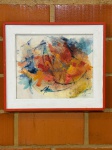 QUADRO - Pintura em aquarela abstrata em uma moldura vermelha e branca. A obra de arte apresenta cores vibrantes, predominantemente tons de vermelho, laranja e amarelo, com toques de azul e preto. A assinatura do artista e a data '02' Med. 59x50 cm. Marcas do tempo e de uso.