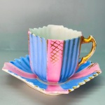 PORCELANA - Xícara de café porcelana azul, rosa e dourado, borda serrilhada. Med. 4x6x5 cm. Desgastes.