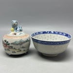PORCELANA - Lote de antiga gaiola para grilo com pegador em formato de cão de fó, respiros em forma de coração, decorado com cena de pagode. Med. 10x7,5 cm e tigela em azul e branco, dita em grãos de arroz. Med. 6x11 cm. Bicados.