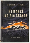 Livro: MOURA, Reynaldo. `Romance no Rio Grande`, 1ª edição autografada. Porto Alegre: Editora Globo, 1958; 166p. Broch. Dedicatória do autor.