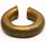 Numismática, Ogondo ou manila. Moeda de troca e adorno de origem africana. Possui o formato de pulseira. Muito colecionável, com grande procura no mercado numismático internacional e também como peça exótica. No Brasil já existem recentes publicações à respeito. Exemplar proveniente de coleções europeias de mais de 50 anos de garimpo. Imponente peça com detalhes tribais, muitas marcas de uso. Centenária. 537g. 8,5x9cm. 