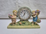 Lindo relógio de mesa com moldura na forma de de meninos em resina, maquinário à quartz. Medindo 23cm x 6cm x 14,5cm de altura. Necessita de revisão. Peça com restauro