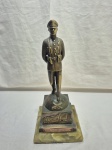 Escultura comemorativa de um Carabineiro do Chile em bronze com base em pedra sabão. Medindo a base 14cm x 8cm x 15cm de altura total.