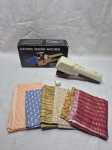 Lote de maquina de costura Electric Sewing Machine com alguns retalhos. Medindo o tecido laranja 144cm x 31cm. Não testado por falta de pilhas.