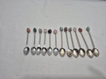 Jogo de 12 colheres em metal com cabo torcido e pedras na ponta, sendo 6 de chá e 6 de café. Medindo 11cm de comprimento.
