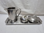 Lote de bule, açucareiro, manteigueira e bandeja retangular em aço inox. Medindo a bandeja 40cm x 16cm.