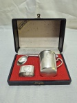 Kit infantil com 3 peças em prata 90 Belprata, sendo caneca, colher torta e argola de guardanapo. Medindo o copo 6cm x 6,5cm de altura.