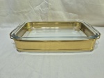 Travessa retangular em vidro temperado com suporte em metal dourado. Medindo a travessa 34,5cm x 21cm x 5cm de altura.