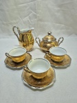 Jogo de servir café com 5 peças em porcelana Mauá com pintura ouro. Sendo leiteira, açucareiro e 3 xícaras. Medindo a leiteira 11cm de altura. Com desgaste na douração.
