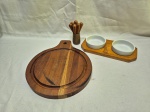 Lote de tábua de queijo em madeira, garfos de petisco em madeira e par de bowls em porcelana com suporte em madeira. Medindo a tabua 22cm de diâmetro.
