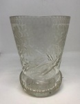 Lindo vaso em cristal apresenta um padrão gravado ou em relevo na superfície, possivelmente com motivos florais ou botânicos (similar a folhas ou pinhas), que confere um toque elegante e vintage. A base também possui detalhes decorativos. Mede: 15x12.