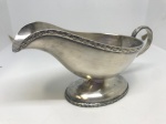 Molheira ou barco de molho prateado, banhado a prata, com um design clássico e elegante. Possui uma alça curvada e um bico para facilitar o despejo, além de detalhes gravados na borda superior e na base. A base é oval e elevada. Mede: 9x16.
