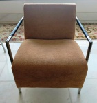 Poltrona moderna com braços em metal e estofamento em tecido pêssego. Mede: 65x75x80 cm