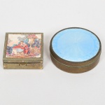 COLECIONISMO, duas (2) caixas pequenas confeccionadas em metal: 1 antiga em bronze com espelho interno (espelho trincado na borda), tampa esmaltada em azul, fundo em guilhoché, punção de manufatura parcialmente legível não identificado, medindo 5 cm diâmetro e 1,5 cm altura; 1 com tampa ornada em lito policromada representando cena de galanteio, sinais de oxidação, medindo 4 x 4 x 1,2 cm, ambas com sinais de uso, vide foto.