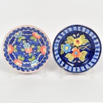 CERÂMICA PORTUGUESA, dois (2) pratos decorativos, esmaltação vítrea policromada, pintado a mão, representando flores, um deles assinado Maria, marca de Olaria Portuguesa no verso, medindo 15,5 cm diâmetro, vide foto.
