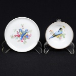 PORCELANA ALEMÃ, dois (2) itens distintos: 1 pequeno bowl e 1 pratinho (tricas visto somente no verso), ornados com pássaros em policromia, marca AK KAISER - ALKA (Composição oriunda das iniciais das duas famílias Alboth e Kaiser donos da fábrica de porcelana alemã, fundada em 1872, em Coburg, por August Alboth; em 1899 mudou-se para Kronach; no decorrer dos anos foi mudando a nomeclatura da fábrica como segue: 1872 a 1928 (Porzellanveredelung August Alboth); 1928 a 1951 (Porzellanfabrik AL-KA Kunst Alboth & Kaiser); 1951 a 1956 (Porzellanfabrik AL-KA Kunst Alboth & Kaiser K. G.); 1956 a 1970 (Porzellanfabrik AL-KA Kunst Alboth & Kaiser K. G. Staffelstein); 1970 a 2001 (Kaiser-Porzellanmanufaktur Staffelstein K. G.); a partir de 2001 até a atualidade (Kaiser-Porzellanmanufaktur Staffelstein G.m.b.H. & Co. K.G.), medindo a maior peça 10,5 cm diâmetro, sinais de uso, vide foto.