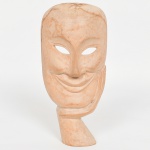 ESCULTURA, uma (1) representando máscara, entalhada em madeira, origem ignorada, faltando parte junto a base, medindo 23,5 cm altura, vide foto.