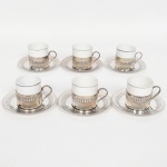 PORCELANA E METAL PRATEADO, seis (6) xícaras para café, cilíndricas, tonalidade branca, arremates com frisos prateados, sem marca de manufatura aparente, monture e pires das marcas CRISTOFOLI e WOLFF, todas com sinais de uso, vide foto.
