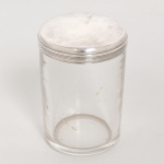 VIDRO E METAL PRATEADO, um (1) antigo pote cilíndrico, incolor e translúcido, tampa da marca HALPHEN (Charles Halphen, ourives parisiense ativo no século XIX, estabelecido na 4 Rue D Hauteville, Paris), lisa e canelada na horizontal da borda, medindo 10 cm altura e 7 cm diâmetro, sinais de uso, vide foto.