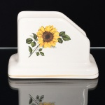 FAIANÇA, um (1) porta guardanapo com ornamentação floral policromada, arremate com friso a ouro, sem marca de manufatura aparente, medindo 14 x 8,5 x 9,5 cm, sinais de uso, vide foto.