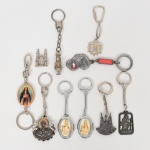 COLECIONISMO, dez (10) itens com motivos sacros, a grande maioria confeccionada em metal: 1 escultura miniatura representando Catedral; 9 chaveiros distintos, vide foto.