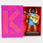 ESCULTURA, uma (1) representando violeiro, confeccionada em papel com base em madeira, selo da Casa D Arte  A Bela Arte em Papel, artesão Leandro Leal Oliveira, Rua Pedro Gomes 26, Conservatória, RJ, medindo 19,5 cm altura, vide foto.