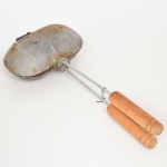 EQUIPAMENTO DE COZINHA, uma (1) assadeira para pão francês, marca GAMBOA, confeccionada em metal, pegas em madeira torneada, medindo 31 cm comprimento, sinais de uso, vide foto.