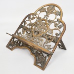 BRONZE, uma (1) estante de mesa, para leitura da Bíblia Sagrada, vazada em folhas, selo da DR (D Rocha Real), falta um parafuso na parte de traz, medindo fechada 37 x 31,5 cm, sinais de uso, vide foto.