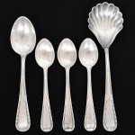 FAQUEIRO, cinco (5) talheres: 1 concha para açucareiro; 3 colheres de café; 1 colher de chá, manufatura WOLFF (tradição desde 1894), ornamentação relevada com guirlandas de tulipas, frisos e folhas, medindo a maior peça 15 cm comprimento, confeccionados em metal prateado, vide foto.