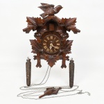 RELÓGIO, um (1) antigo de parede, dito CUCO, gabinete entalhado em madeira com pássaro e elementos vegetalistas, marca representada pela letra H dentro de uma Estrela de David, possui os pesos para acionar o mecanismo, medindo 39 cm altura, aparentemente em bom estado, usado, não testado e sem garantia, vide foto.