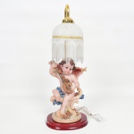 LUMINÁRIA, um (1) abat-jour de grande dimensão para um lume, base representando anjo musicista, confeccionada em resina policromada, cúpula em vidro acetinado com mesclados na tonalidade branca, ornada com penduricalhos em canutilhos e miçangas, funcionando, medindo 61 cm altura, sinais de uso, vide foto.