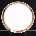 PORCELANA, um (1) prato medalhão, para torta ou bolo, ornado com faixa na tonalidade bordo, generosos arremates a ouro, manufatura STEATITA (Campo Largo, PR, funcionou de 1954 a 1994), medindo 27 cm diâmetro, sinais de uso, vide foto.