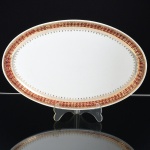 PORCELANA, uma (1) travessa oval, ornada com faixa na tonalidade bordo, generosos arremates a ouro, manufatura STEATITA (Campo Largo, PR, funcionou de 1954 a 1994), medindo 28,5 x 18 cm, sinais de uso, vide foto.