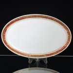 PORCELANA, uma (1) travessa oval, ornada com faixa na tonalidade bordo, generosos arremates a ouro, manufatura STEATITA (Campo Largo, PR, funcionou de 1954 a 1994), medindo 32 x 20 cm, sinais de uso, vide foto.