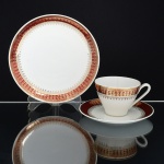 PORCELANA, um (1) trio para chá (xícara, pires e prato de bolo), ornados com faixa na tonalidade bordo, generosos arremates a ouro, manufatura STEATITA (Campo Largo, PR, funcionou de 1954 a 1994), medindo a maior peça 19 cm diâmetro, ideal para coleção de cristaleira, sinais de uso, vide foto.