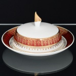 PORCELANA, uma (1) manteigueira com presentoir acoplado, ornada com faixa na tonalidade bordo, generosos arremates a ouro, manufatura STEATITA (Campo Largo, PR, funcionou de 1954 a 1994), medindo 16 cm altura, sinais de uso, vide foto.