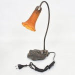 LUMINÁRIA, um (1) abat-jour para um lume, padrão Art Nouveau, base relevada em elementos vegetalistas, cúpula em vidro na tonalidade âmbar com mesclados em branco e borda drapeada, parte elétrica funcionando, medindo 40 cm altura, sinais de uso, vide foto.