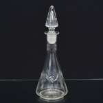 VIDRO, uma (1) licoreira com tampa, incolor e translúcida, lapidada em sulcos, formando padrões geometrizados, fundo estrelado, medindo 26 cm altura, sinais de uso, vide foto.