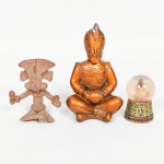 DIVERSOS, três (3) itens misticos distintos: 1 escultura representando Guru Indiano em posição de meditação, confeccionada em estuque e patinada, pequenas falhas, medindo 14,5 cm altura; 1 escultura figurativa inspirada nas antigas Civilizações Pré Colombianas, modelada em barro e cozida, medindo 9 cm altura, perna quebrada e colada; 1 objeto decorativo representando cabeça de Faraó, dentro de esfera com líquido, base em hieroglifos, medindo 7 cm altura, souvenir do Egito, confeccionada em materiais variados, vide foto.