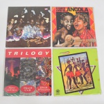 MÚSICA, quatro (4) LPs em vinil: Cananito Alexandre (Luanda  Angola); Trilogy; O Canto Livre de Angola; Jacinto Tchipa (Luanda - Angola), todos aparentemente em bom estado, usados e sem garantia, vide foto.
