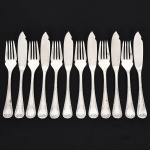 FAQUEIRO, doze (12) talheres para peixe, confeccionados em metal prateado, manufatura FRACALANZA (tradição desde 1884), ornamentação no padrão Art Nouveau, relevada em frisos e folhas terminando em laçarote, sendo: 6 espátulas e 6 garfos, sinais de uso, vide foto.