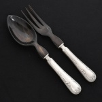 FAQUEIRO, conjunto para salada com dois (2) talheres: 1 colher e 1 garfo, confeccionados em metal prateado, extremidades entalhadas em chifre, manufatura FRACALANZA (tradição desde 1884), ornamentação no padrão Art Nouveau, relevada em frisos e folhas terminando em laçarote, sinais de uso, vide foto.