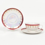 PORCELANA, uma (1) xícara de chá com um pires sobressalente, fundo nacarado, faixa na tonalidade magenta, silhuetas geométricas e vegetalistas a ouro, além de frisos, bicado na borda da xícara, marca ABECE (Porcelana ABECE Ltda., Santo André, SP, funcionou entre as décadas de 60 e 90), ideal para coleção de cristaleira, vide foto.