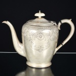 METAL PRATEADO INGLÊS, um (1) bule de café, ornamentação burilada e cinzelada em elementos vegetalistas, pega da tampa em polímero, alça curvilínea, marca representada por trevo com estrelas dentro das pétalas (fundada em 1801 por Mary Barker, como Barker Bros, logo depois o negócio foi continuado pelo filho William Barker em parceria com Creed; mudou de nome várias vezes: Barker & Creed; William & Matthias Barker; Barker Brothers; Barker Brothers Silversmiths Ltd.; Barker Ellis Silver Company Ltd.), ladeado pelas letras EP BM (electro plate britain metal), Made in England, medindo 20 cm altura, sinais de uso, vide foto.