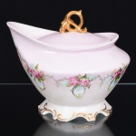 PORCELANA, um (1) pequeno gomil de pé baixo e com tampa, ornamentação floral policromada, pintados a mão pelo atelier ZAIRA, manufatura SCHMIDT (Pomerode, SC; Mauá, SP; Campo Largo, PR, fundada em 1945, ainda em atividade, maior fábrica de porcelana da América Latina), medindo 17 cm altura, sinais de uso, vide foto.