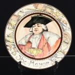 FAIANÇA INGLESA, um (1) prato decorativo policromado representando retrato de figura da corte, legenda The Mayor, manufatura ROYAL DOULTON (fundada em 1815 como JONES, WATTS & DOULTON parceria entre John Doulton, Martha Jones e John Watts em Vauxhall Walk, Lambert, Londres; em 1820 virou DOULTON & WATTS com a saída de Martha Jones; em 1854 virou DOULTON & Co. com a aposentadoria de John Watts e a fusão com a HENRY DOULTON & Co.; em 1902 virou ROYAL DOULTON através de concessão real; em 2009 passou a ser administrada pela Holding WWRD Waterford Crystal, Wedgwood, Royal Doulton; em 2015 foi adquirida pela empresa finlandesa FISKARS CORPORATION), medindo 27 cm diâmetro, vide foto.