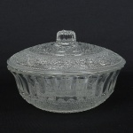 VIDRO, uma (1) pequena bomboniere ou porta confeitos com tampa, incolor e translúcida, moldada em caneluras,bico de jaca, perolados e elementos vegetalistas, origem Malásia, pega da tampa canelada, medindo 13 cm diâmetro,sinais de uso, vide foto.