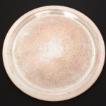 METAL PRATEADO, uma (1) bandeja circular, fundo com ornamentação em baixo relevo representando: pérgulas, volutas e elementos vegetalistas, sem marca de manufatura aparente, sinais de uso, demanda novo banho em prata, medindo 49 cm diâmetro, vide foto.