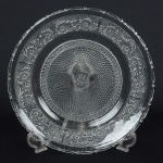 VIDRO, um (1) prato de bolo, incolor e translúcido, moldado em losangos, perolados e elementos vegetalistas,medindo 30 cm diâmetro, sinais de uso, vide foto.